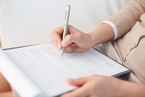pressmaster130200276.jpg - female counselor writing down some information about her patient